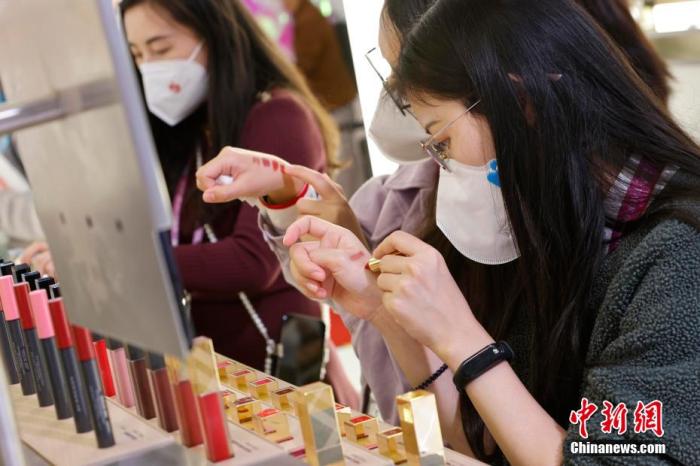 圖為女生正在體驗口紅產(chǎn)品。 殷立勤 攝