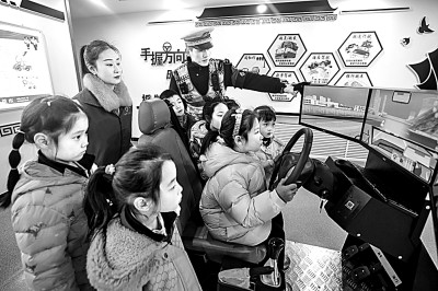 山東省榮成市公安局道路交通安全宣傳教育基地，交警帶領(lǐng)小學(xué)生現(xiàn)場(chǎng)體驗(yàn)?zāi)M駕駛。新華社發(fā)