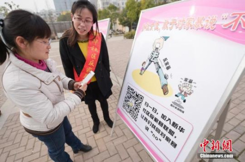 資料圖：今年3月8日，安徽合肥新華社區(qū)志愿者夏一瓊(右)向市民普及反家暴相關(guān)法律知識(shí)。鐘欣 攝