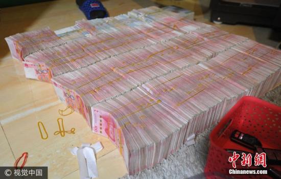 廣西南寧警方8月21日通報,當(dāng)?shù)亟粘晒善粕姘附痤~15.19億元人民幣的特大傳銷案件。圖為當(dāng)場繳獲的成捆現(xiàn)金。圖片來源:視覺中國