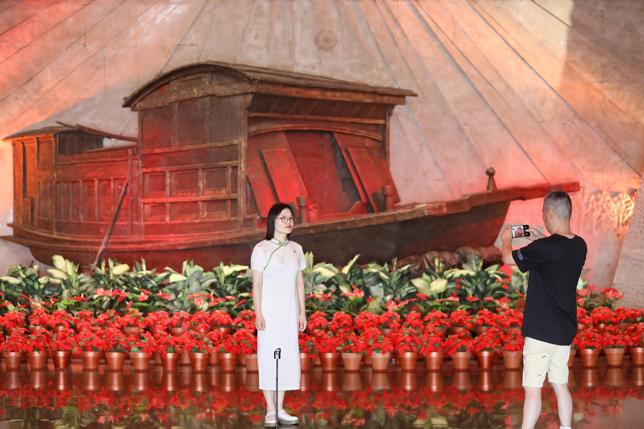 2025年6月24日，浙江嘉興，游客在南湖革命紀念館與紅船雕塑合影。（圖片來源：視覺中國）